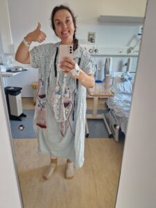 Ellie with a post-surgery selfie in her hospital robes.