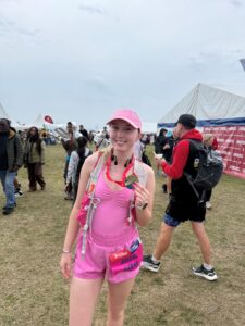 Abigail dressed in all pink holding her medal at the finish of the Great North Run