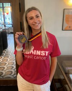 Alexa in a pink ABC t-shirt holding her medal