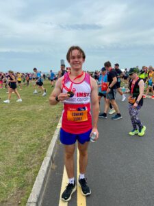 Edmund holding his medal at the finish of the Great North Run,