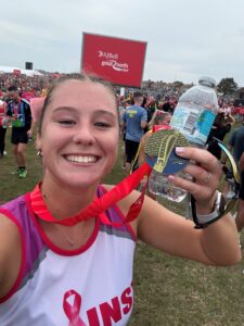 Marie person holding a medal and a water bottle at the finish of the Great North Run