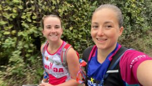 Polly and her friend take a selfie during the challenge with a bush behind them.
