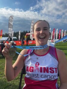 Polly holding her medal after finishing the Chiltern 50 Ultra Challenge