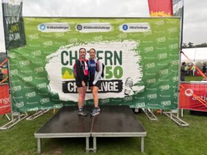 Polly and her friend stand on a podium at the race finish.