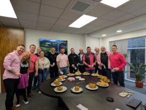The EDSB team, many dressed in pink, during their Against Breast Cancer fundraiser with the entries to the pie competition laid out on a back table.