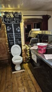 An actual toilet (non-functioning we hope!) for the Toss the Toilet Roll game at Merry Miller's Pubs in Pink