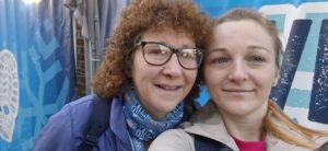 Mandy and Emma selfie in front of a light blue back drop